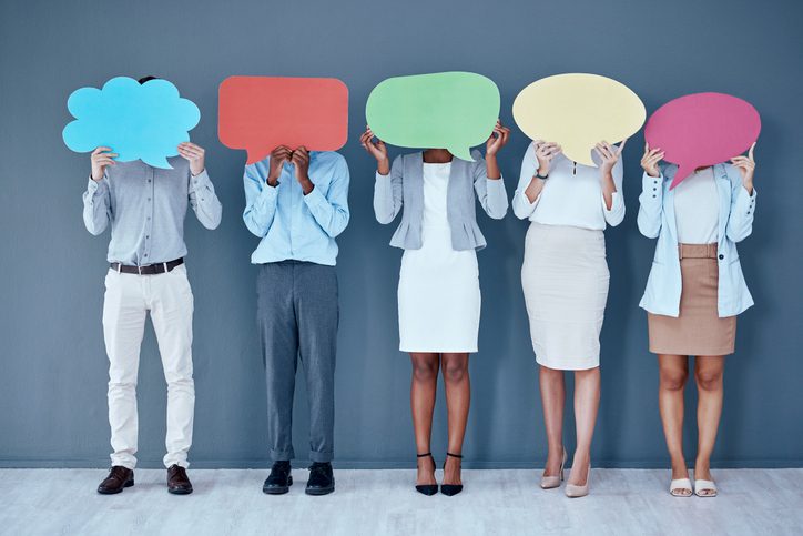 Five people holding colorful speech bubbles in front of their faces, standing against a blue-gray background.